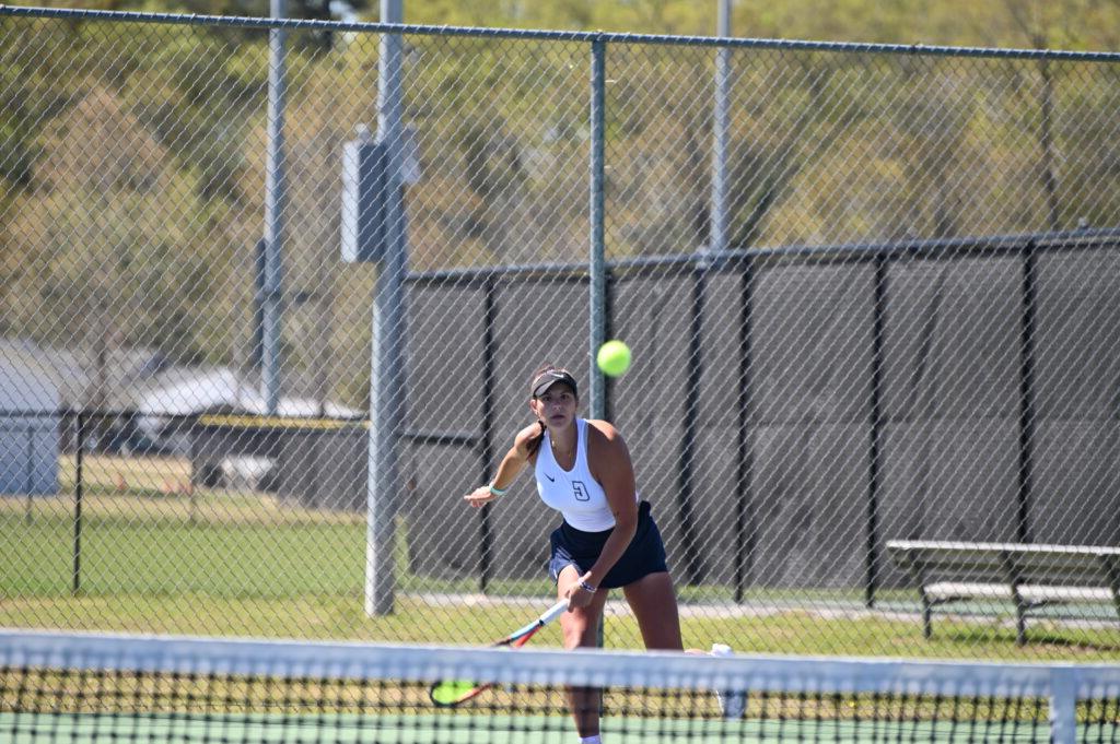 A Coker tennis player serves the ball.